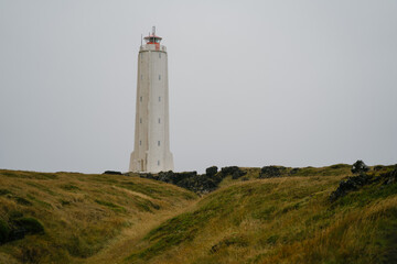 Fototapeta na wymiar Malarrif lighthouse on the cliff near the ocean in Western Iceland. Snaefellsnes (Snæfellsnes) peninsula