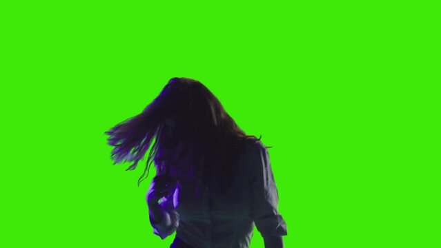 An attracrtive model girl is dancing with head shaking in slowmotion on greenscreen
