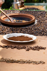traditional roasting of coffee beans in a clay bowl, roasted beans and green beans