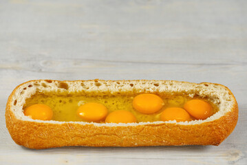 huge sandwich with raw eggs inside. Stuffed big ciabatta bread with raw ingredients ready to bake in the oven. the process of making pie or snacks. close up