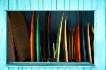 Set of colorful surfboards for rent or sell. Surf boards displayed next to a beach