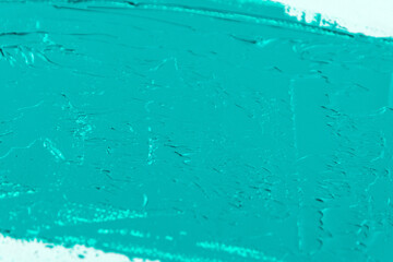 wide stroke of turquoise paint on a white coarse weave art gauze close-up, toning, free space