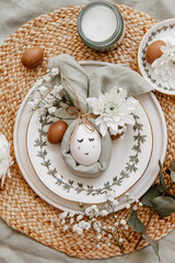 Napkin folder idea. Easter table. Easter holiday table setting with egg in grey napkin Easter Bunny on a brown linen background. Copy space, top view, flat lay.