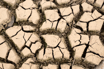 Soil cracked from drought at the bottom of a reservoir without water