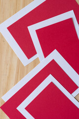 paper shapes in white and red on a wooden surface