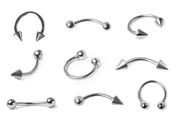 Set with different piercing jewelry on white background