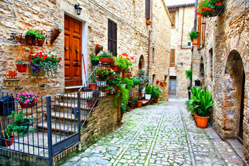 Charming floral narrow streets of typical italian villages. Spello in Umbria famous with fllower decorated walls. Italy