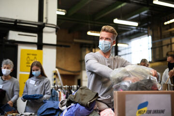 Volunteers sorting out donated clothes for the needs of Ukrainian migrants, humanitarian aid...
