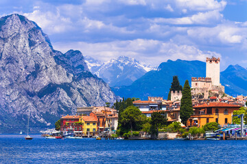 Idyllic lake scenery - beautiful Lago di Garda, view of Malcesine village surrounded by Alps...