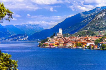 Obraz premium Idyllic lake scenery - beautiful Lago di Garda, view of Malcesine village surrounded by Alps mountains. North of Italy