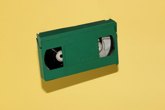 green old vhs cassette retro style on pastel yellow background