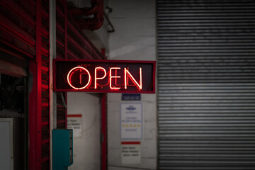 Open red neon sign grunge laneway car park entrance garage door late dark night