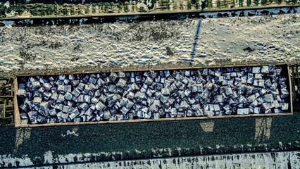 Resources on the winter train yard with snow on the ground and items in the cargo container.