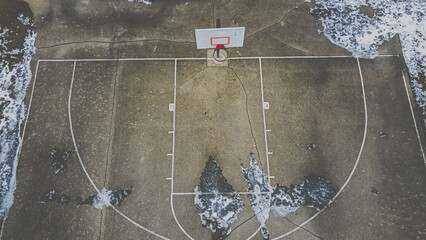 Ice and snow cover this basketball court at a rural public park.