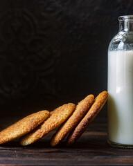 milk and peanut cookies with chocolate on a dark background 