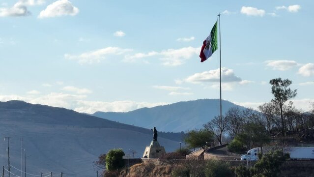Flag of Mexico waving in the wind over Oaxaca city