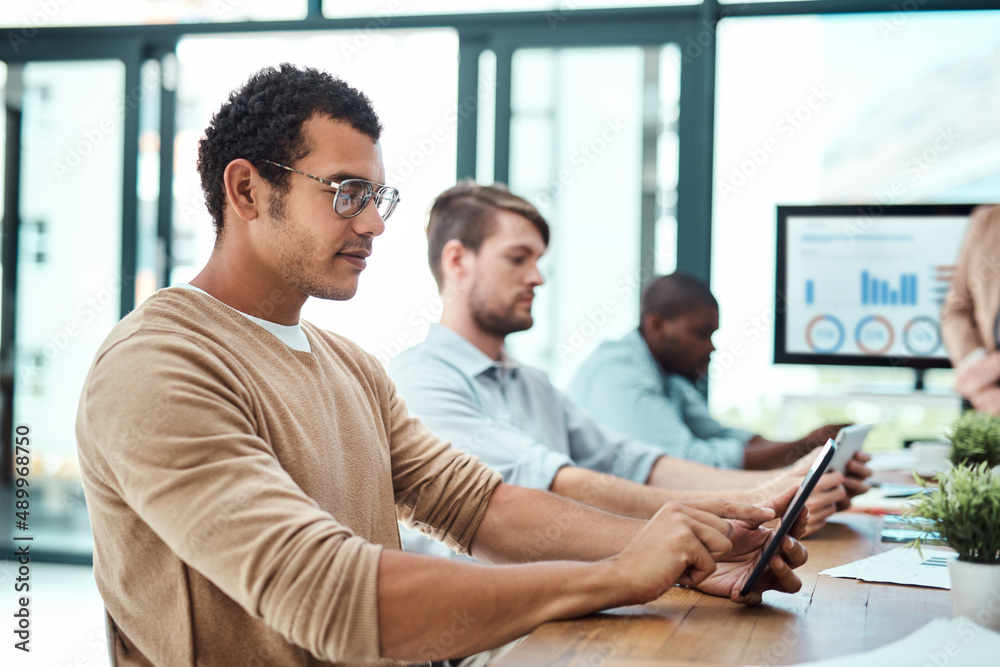 Poster Making moves with the right tools. Shot of a group of businesspeople working in an office.
