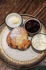 Scones with Strawberry Jam and Clotted Cream on wooden table black background. Delicious freshly baked homemade