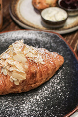 Almond croissant butter. Traditional French breakfast tray with gold and crispy croissants