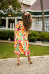 Woman posing with hand on head facing away