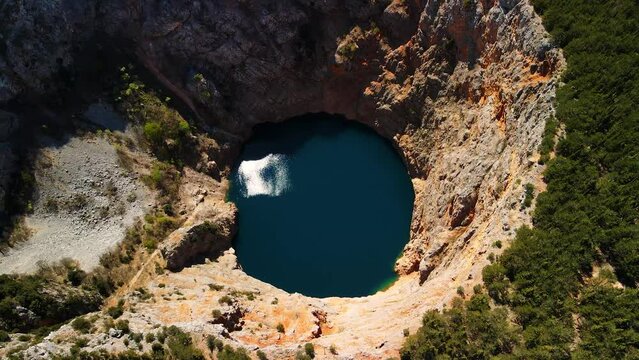 Beautiful scenic landscape view of the Red lake. The biggest limestone crater and sinkhole in Europe. Containing Karst Lake with high cliffs and a deep lake in Croatia, Europe. A picturesque location.