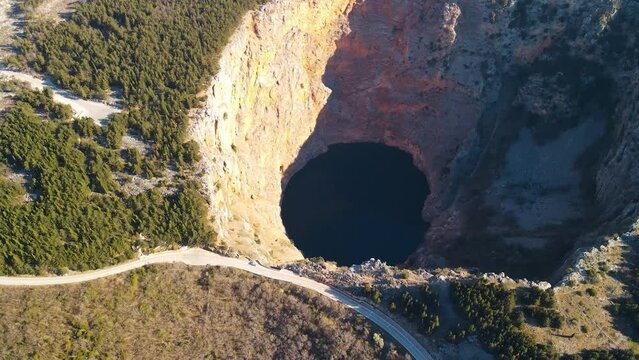 Beautiful scenic landscape view of the Red lake. The biggest limestone crater and sinkhole in Europe. Containing Karst Lake with high cliffs and a deep lake in Croatia, Europe. A picturesque location.
