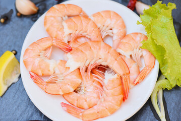 Fresh shrimps served on white plate, boiled peeled shrimp prawns cooked in the seafood restaurant - top view