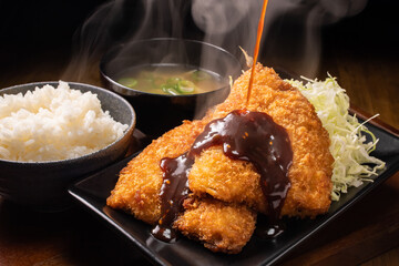 アジフライに赤味噌仕立てのタレをかける。