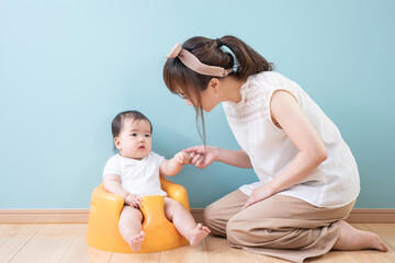 水色の壁の前にいる親子
