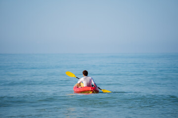 man paddling a kayak boat in sea