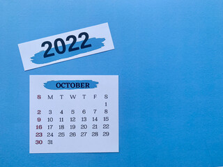 October 2022 white calendar with blue background. 2022 new year concept