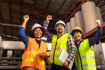 Engineer asian and african woman wearing safety helmet and vest holding clipboard and take note on the paper in the automotive part warehouse.Products and corrugated cardboard.  .