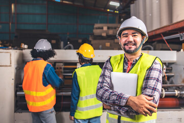 Engineer asian worker wearing safety helmet and vest holding clipboard and take note or tablet in the automotive part warehouse.Products and corrugated cardboard.