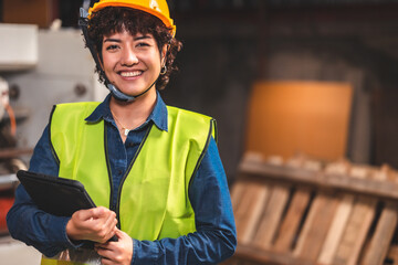 Engineer asian worker wearing safety helmet and vest holding clipboard and take note or tablet in the automotive part warehouse. 