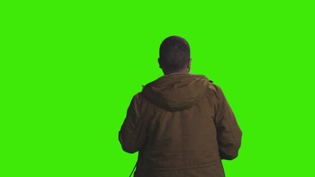 A happy young boy is dancing at disco facing the opposite direction on greenscreen