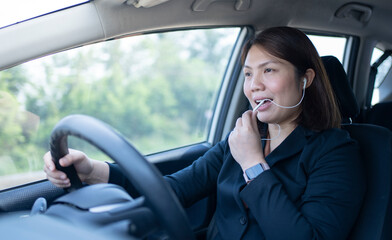 Businesswoman using earphone for talking business in a car on driving