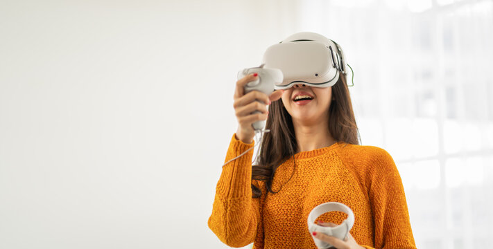 Young woman using glasses of virtual reality on white background. beautiful girl using with VR headset,AR,metaverse,virtual reality,future technology concept.Asian woman using VR glasses in white room