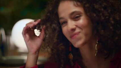 Flirting woman touching hair on restaurant date. Shy girl smiling looking sexy.