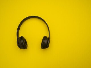 Top view of black headphones on yellow background