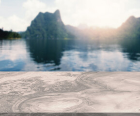 Blank space of marble table with the background of lake and mountainscape in a morning, rising sun, empty space for product presentation on the table.