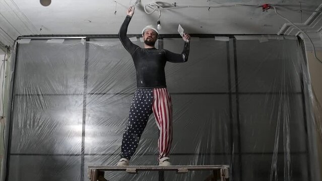 In the large space building construction dancing in front of the camera engineer man with safety equipment he enjoy the moment at the end of the day