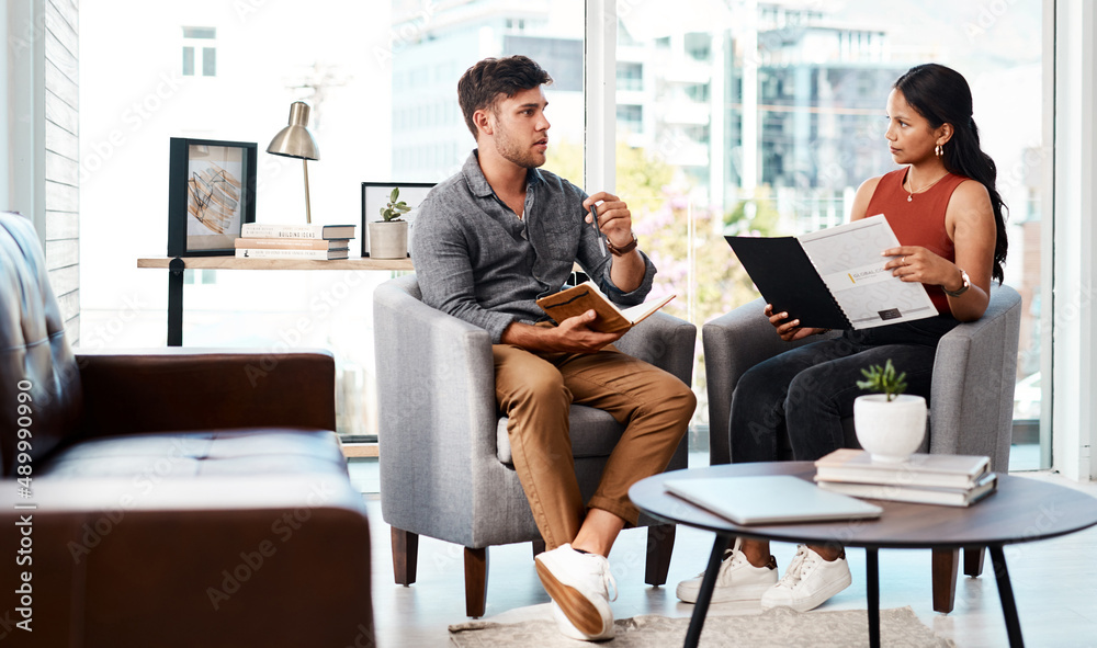 Poster Running through their game plan from concept to completion. Shot of two young designers having a discussion in an office.