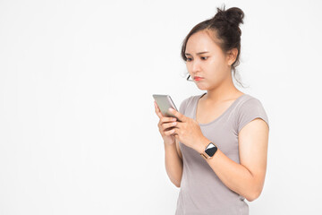Naklejka premium Beautiful Asian woman wearing grey casual shirt holding smartphone on white background and copy space. Cute Asian woman is angry and chatting about something for social media concept