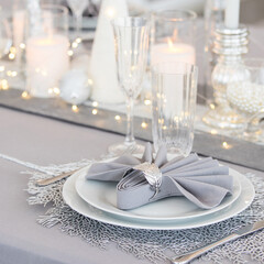 Beautiful table setting with Christmas decorations. Silver colors