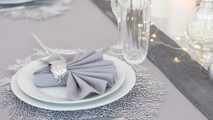 Beautiful table setting with Christmas decorations. Silver colors