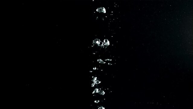 Air bubbles under water rise upwards. On a black background.Filmed on a high-speed camera at 1000 fps. High quality FullHD footage