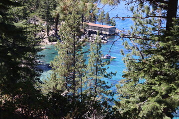 Lake tahoe with boats and woodlands. Many green trees