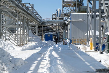Fototapeta premium Magadan / Russia - 03.20.2019 : Workers in overalls pass through the territory of the metallurgical plant