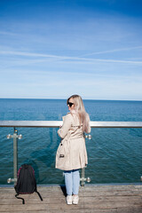 Close up fashion details,  girl pouring at the beach, casual outfit, backpacker, traveler, cold weather.