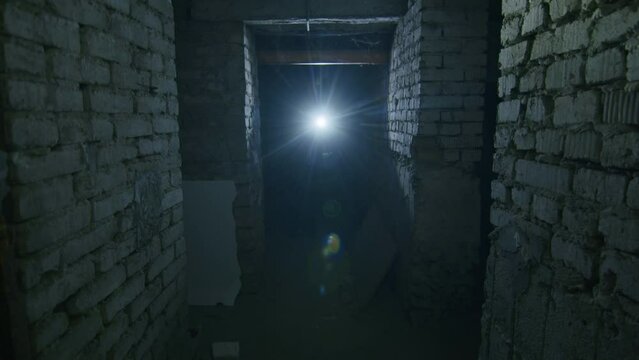 a girl in a terrible state searches a scary basement to find a possible shelter in case of a bomb explosion. News about tensions between Ukraine and Russia. Russian aggression. The threat of war.